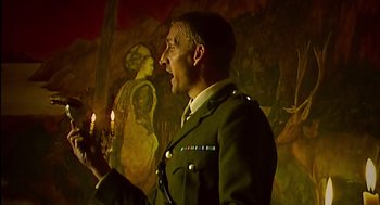 Movie still from “28 Days Later” (2002), directed by Danny Boyle – A man in a military uniform holding a lit candle; Medium shot, Low angle