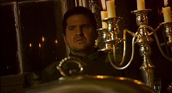 Movie still from “28 Days Later” (2002), directed by Danny Boyle – A man looking into a mirror in a dimly - lit room; Close Up shot, High angle