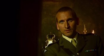 Movie still from “28 Days Later” (2002), directed by Danny Boyle – A man in a military uniform with a watch on his shoulder; Close Up shot, Over the shoulder angle