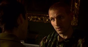 Movie still from “28 Days Later” (2002), directed by Danny Boyle – A man in a camouflage shirt talking to another man; Close Up shot, Over the shoulder angle