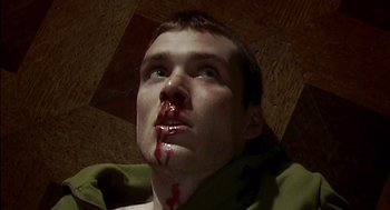 Movie still from “28 Days Later” (2002), directed by Danny Boyle – A young man with blood all over his face; Close Up shot, High angle