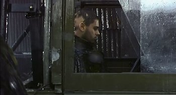 Movie still from “28 Days Later” (2002), directed by Danny Boyle – A man with a shaved head looking out of a window; Close Up shot, Low angle