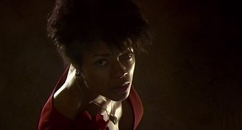 Movie still from “28 Days Later” (2002), directed by Danny Boyle – A woman in a red shirt is looking at the camera; Close Up shot, Low angle