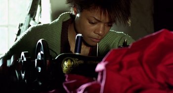 Movie still from “28 Days Later” (2002), directed by Danny Boyle – A woman using a sewing machine to sew clothes; Close Up shot, Low angle
