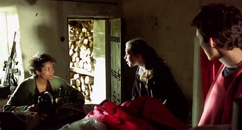 Movie still from “28 Days Later” (2002), directed by Danny Boyle – A person sitting in a room looking out the window; Medium shot, Low angle