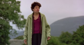 Movie still from “28 Days Later” (2002), directed by Danny Boyle – A woman in a green coat standing on a hill; Medium shot, Low angle
