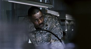 Movie still from “28 Weeks Later” (2007), directed by Juan Carlos Fresnadillo – A man in military fatigues looking at the camera; Medium shot, Over the shoulder angle