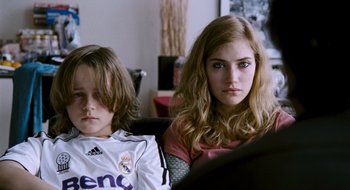 Movie still from “28 Weeks Later” (2007), directed by Juan Carlos Fresnadillo – A young girl sitting next to a young boy in a chair; Close Up shot, Over the shoulder angle