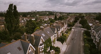 Movie still from “28 Weeks Later” (2007), directed by Juan Carlos Fresnadillo – An aerial view of a residential area with a lot of trees; Extreme Wide shot, High angle