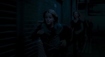 Movie still from “28 Weeks Later” (2007), directed by Juan Carlos Fresnadillo – Two people running in the dark in a dark alley; Medium shot, High angle