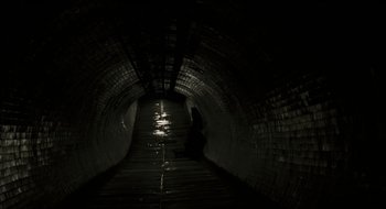 Movie still from “28 Weeks Later” (2007), directed by Juan Carlos Fresnadillo – A dark tunnel with a person in the middle of the tunnel; Extreme Wide shot, High angle