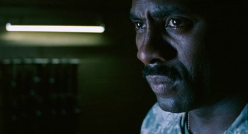 Movie still from “28 Weeks Later” (2007), directed by Juan Carlos Fresnadillo – A man's face in a dark room; Close Up shot, Over the shoulder angle