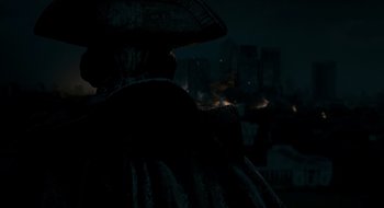 Movie still from “28 Weeks Later” (2007), directed by Juan Carlos Fresnadillo – A man in a pirate costume standing in front of a city at night; Close Up shot, Over the shoulder angle