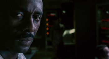 Movie still from “28 Weeks Later” (2007), directed by Juan Carlos Fresnadillo – A man's face in a dark room; Close Up shot, Over the shoulder angle