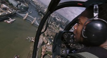 Movie still from “28 Weeks Later” (2007), directed by Juan Carlos Fresnadillo – A man flying a helicopter over a river; Wide shot, Overhead angle