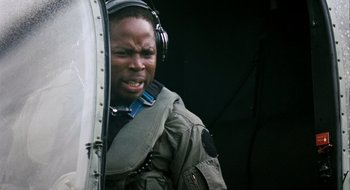 Movie still from “28 Weeks Later” (2007), directed by Juan Carlos Fresnadillo – A man with headphones is standing inside a helicopter; Close Up shot, Low angle