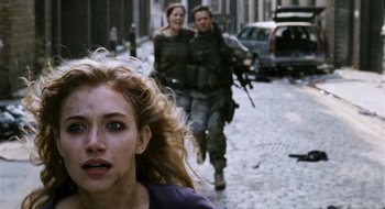 Movie still from “28 Weeks Later” (2007), directed by Juan Carlos Fresnadillo – Two people walking down the street with guns in their hands; Close Up shot, Over the shoulder angle