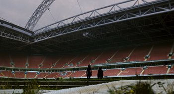 Movie still from “28 Weeks Later” (2007), directed by Juan Carlos Fresnadillo – Two people are standing in an empty stadium; Extreme Wide shot, Low angle
