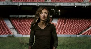 Movie still from “28 Weeks Later” (2007), directed by Juan Carlos Fresnadillo – A woman standing in front of an empty stadium; Medium shot, Low angle