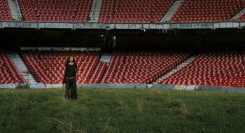 Movie still from “28 Weeks Later” (2007), directed by Juan Carlos Fresnadillo – A woman standing in front of an empty stadium; Extreme Wide shot, High angle