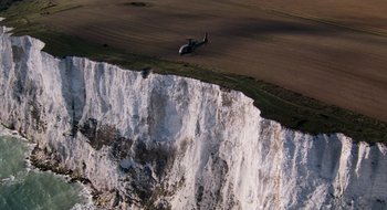 Movie still from “28 Weeks Later” (2007), directed by Juan Carlos Fresnadillo – A helicopter is flying over a cliff face; Extreme Wide shot, High angle