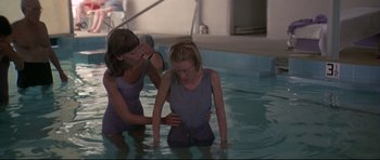 Movie still from “3 Women” (1977), directed by Robert Altman – Two women in a swimming pool one of which is holding a rope; Medium shot, Over the shoulder angle