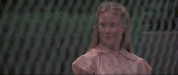 Movie still from “3 Women” (1977), directed by Robert Altman – A young girl in a pink dress smiling for the camera; Close Up shot, Over the shoulder angle