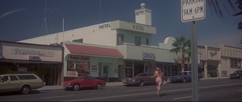 Movie still from “3 Women” (1977), directed by Robert Altman – A woman walking down the street in front of a hotel; Wide shot, Low angle
