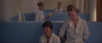 Movie still from “3 Women” (1977), directed by Robert Altman – A group of women in white lab coats sitting on blue benches; Medium shot, Low angle