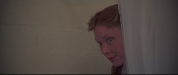 Movie still from “3 Women” (1977), directed by Robert Altman – A young girl looking over a wall at the camera; Close Up shot, Low angle
