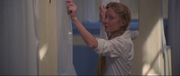 Movie still from “3 Women” (1977), directed by Robert Altman – A woman in a white shirt is hanging a white curtain; Close Up shot, Over the shoulder angle
