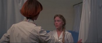 Movie still from “3 Women” (1977), directed by Robert Altman – A woman in a white lab coat looking at another woman in a white lab coat; Close Up shot, Over the shoulder angle