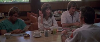 Movie still from “3 Women” (1977), directed by Robert Altman – A group of people sitting at a table with food; Medium shot, Over the shoulder angle