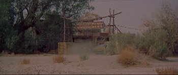 Movie still from “3 Women” (1977), directed by Robert Altman – An old dodge city sign in the middle of a desert; Extreme Wide shot, High angle