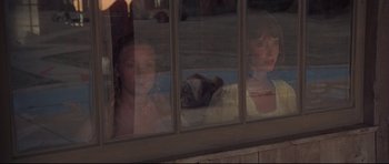 Movie still from “3 Women” (1977), directed by Robert Altman – Two young girls looking out of a window at night; Medium shot, High angle