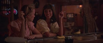 Movie still from “3 Women” (1977), directed by Robert Altman – A woman sitting at a table with a child; Medium shot, Low angle