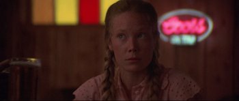 Movie still from “3 Women” (1977), directed by Robert Altman – A woman with braids looking at the camera; Close Up shot, Low angle