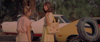 Movie still from “3 Women” (1977), directed by Robert Altman – A woman in a yellow dress holding a yellow purse; Medium shot, Over the shoulder angle