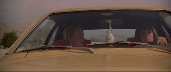 Movie still from “3 Women” (1977), directed by Robert Altman – A woman sitting in the driver's seat of a yellow car; Close Up shot, Low angle