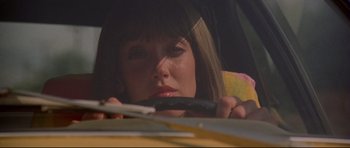 Movie still from “3 Women” (1977), directed by Robert Altman – A woman sitting in a car holding an open umbrella; Close Up shot, Low angle