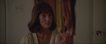 Movie still from “3 Women” (1977), directed by Robert Altman – A young woman smoking a cigarette while looking at the camera; Close Up shot, Over the shoulder angle