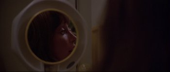 Movie still from “3 Women” (1977), directed by Robert Altman – A woman looking into a mirror in a bathroom; Extreme Close Up shot, Over the shoulder angle