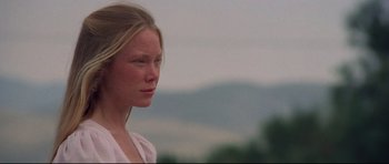 Movie still from “3 Women” (1977), directed by Robert Altman – A young woman is standing in front of a mountain; Close Up shot, Low angle
