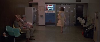 Movie still from “3 Women” (1977), directed by Robert Altman – A woman is walking in front of a vending machine; Wide shot, Over the shoulder angle