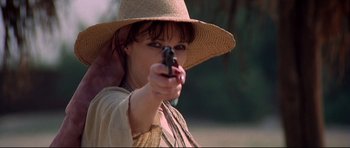 Movie still from “3 Women” (1977), directed by Robert Altman – A woman wearing a straw hat and holding a gun; Close Up shot, Low angle
