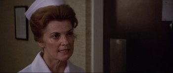 Movie still from “3 Women” (1977), directed by Robert Altman – An older woman wearing a nurse's uniform in front of a wall; Close Up shot, Low angle