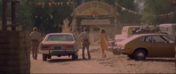 Movie still from “3 Women” (1977), directed by Robert Altman – A man and a woman walking down a street; Wide shot, Over the shoulder angle