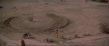 Movie still from “3 Women” (1977), directed by Robert Altman – A person standing in the middle of a dirt field; Extreme Wide shot, High angle