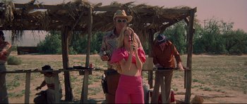 Movie still from “3 Women” (1977), directed by Robert Altman – A woman holding a gun while standing next to a man; Medium shot, Low angle
