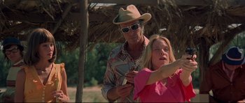 Movie still from “3 Women” (1977), directed by Robert Altman – A man and a woman looking at a cell phone; Medium shot, Low angle